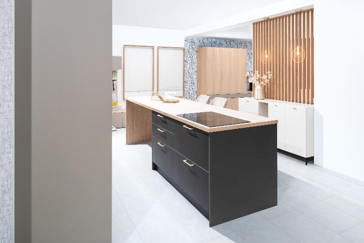 Elegantná kuchyňa od Decodomu s dizajnovým ostrovným pultom, harmonicky kombinujúca čierne a drevené prvky pre moderný domov. Decodom na mieru vytvorená kuchyňa s čiernym ostrovným pultom, drevenými prvkami a elegantným osvetlením.