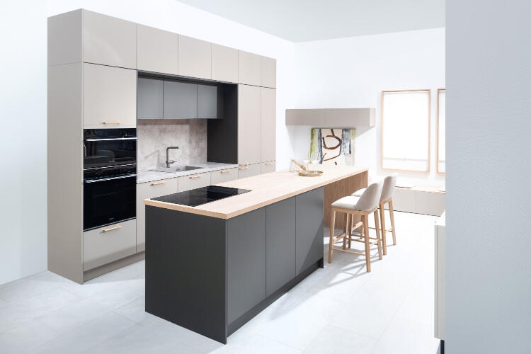 Elegantná kuchyňa od Decodomu s dizajnovým ostrovným pultom, harmonicky kombinujúca čierne a drevené prvky pre moderný domov. Moderná kuchyňa s ostrovným pultom, zabudovanými spotrebičmi a barovými stoličkami v minimalistickom štýle.